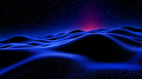 Rolling blue dunes of light stretch under a starry sky, with a faint red glow on the horizon.