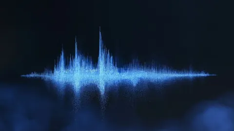 A spike of pale blue particles rises like an audio waveform over a misty dark floor.