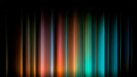 Vertical bars of coral, amber and teal light stand side by side against black, like a split prism.
