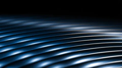 Rows of glossy blue curves stack one above another, catching soft light across their tops.